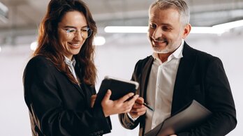 Smiling,Woman,Showing,Digital,Tablet,To,Her,Boss.,Indoor,Shot