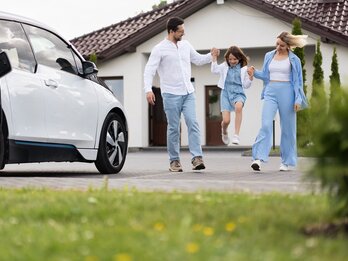 Happy,Family,Enjoying,Time,Together,Near,Electric,Car,Outside,Modern